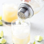 pouring drink from cocktail shaker into glass