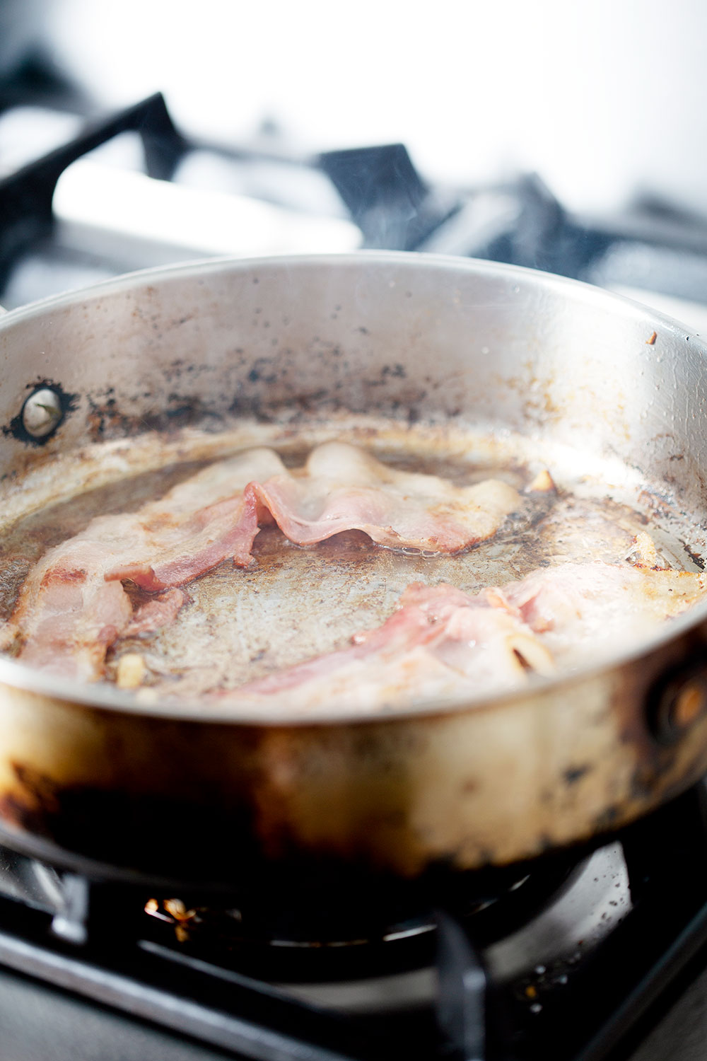 frying bacon in pan on stove top