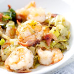 shrimp and onions on white bowl with napkin