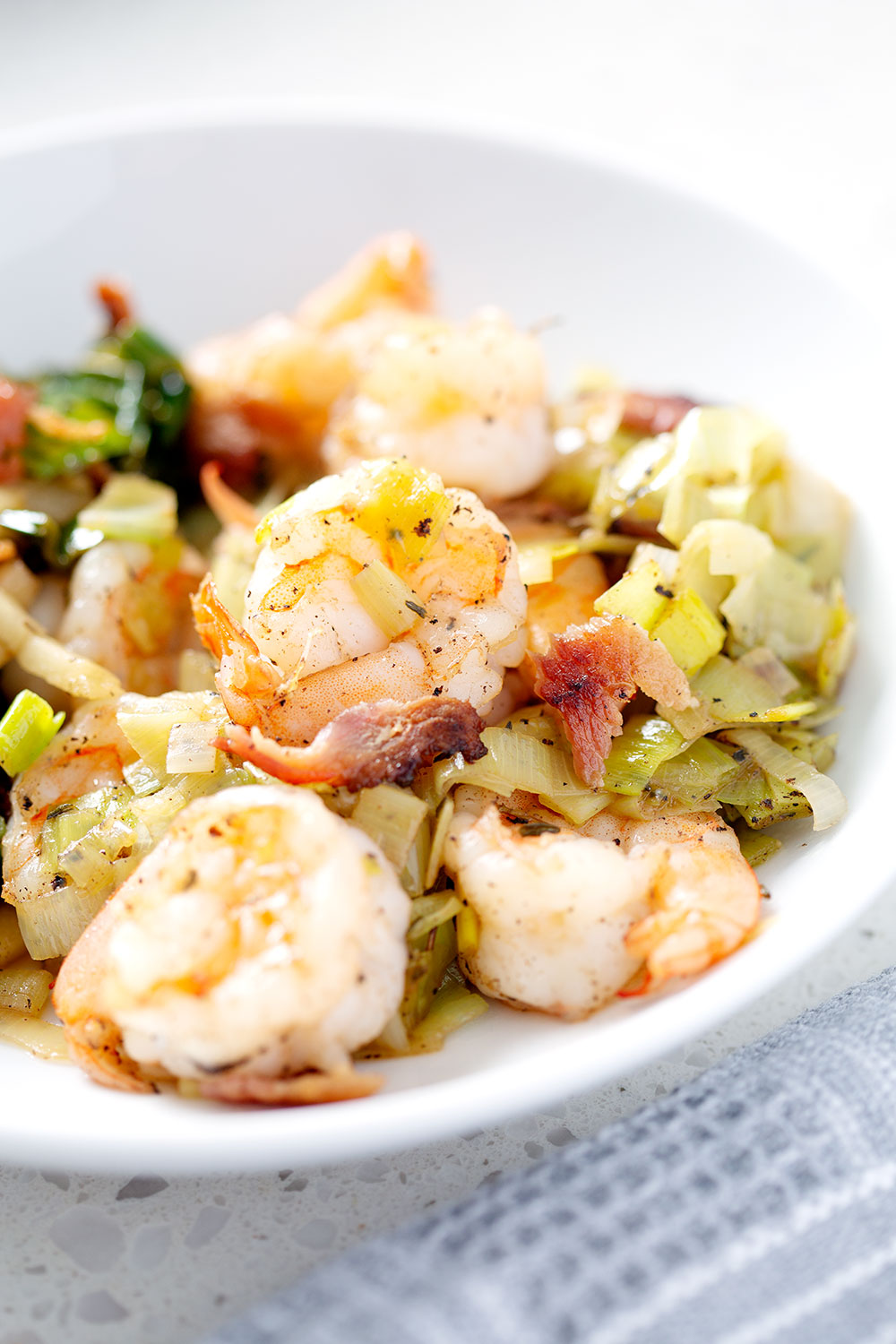 shrimp and onions on white bowl with napkin